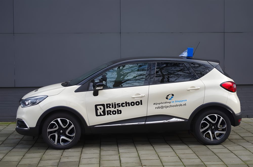 De rode Renault Captur van Rijschool Rob